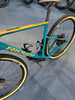 Ein blau-gelbes Ridley-Rennrad mit Gravel-Reifen auf blauem Teppich.