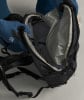 Eine Person zieht Handschuhe an und öffnet einen Rucksack, um etwas hineinzulegen.
