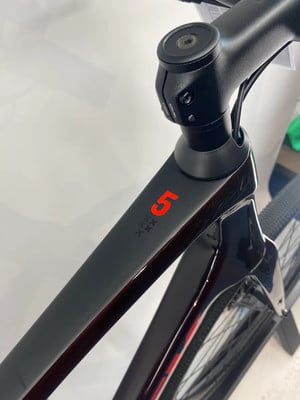 Detail eines Fahrradrahmens mit der Zahl 5 und einem Stern-Logo. Detail eines Fahrradrahmens mit der Zahl 5 und einem Stern-Logo.