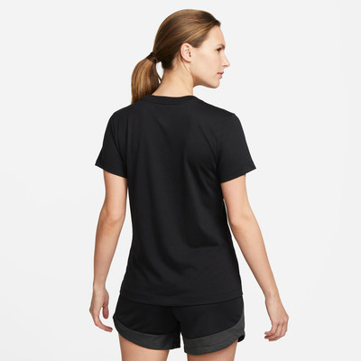 Eine Frau in einem schwarzen T-Shirt und Shorts von hinten vor hellem Hintergrund. Eine Frau in einem schwarzen T-Shirt und Shorts von hinten vor hellem Hintergrund.