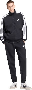 Ein Mann in schwarzer Adidas Trainingskleidung mit weißen Streifen an den Ärmeln und Logo.