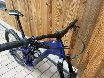 Ein blaues Mountainbike mit schwarzem Lenker und Sattel vor einer Holzwand. Ein blaues Mountainbike mit schwarzem Lenker und Sattel vor einer Holzwand.