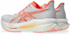 Weiße Laufschuhe mit orangefarbenen Details und Markenlogo.