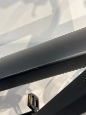 Detail eines Fahrradrahmens mit einem Pedal im Vordergrund.