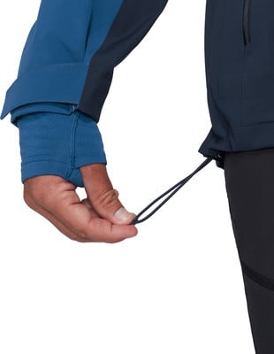 Eine Hand passt die Kordel am Ärmel der Jacke an.