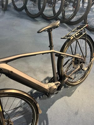 Ein E-Bike der Marke Merida mit Gepäckträger und Schutzblechen steht auf dem Boden.