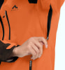 Nahaufnahme einer orangefarbenen Jacke mit McKinley-Logo und einer Hand in einer Tasche.