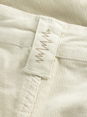 Detail eines Etiketts mit gesticktem Muster auf Cordstoff. Detail eines Etiketts mit gesticktem Muster auf Cordstoff.