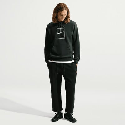 Ein Mann in einem schwarzen Nike Hoodie und Hose steht vor weißem Hintergrund. Ein Mann in einem schwarzen Nike Hoodie und Hose steht vor weißem Hintergrund.