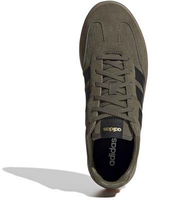 Zöld Adidas férfi cipő fekete csíkokkal és arany logóval. Zöld Adidas férfi cipő fekete csíkokkal és arany logóval.