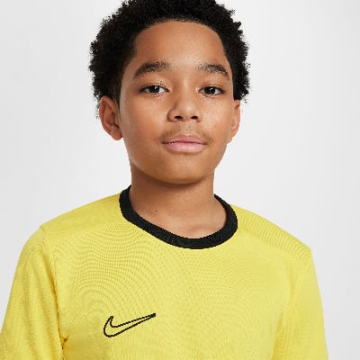 Junge in einem gelben T-Shirt mit schwarzem Kragen und Nike-Logo. Junge in einem gelben T-Shirt mit schwarzem Kragen und Nike-Logo.