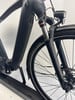 Schwarzes E-Bike mit Federgabel und Licht.
