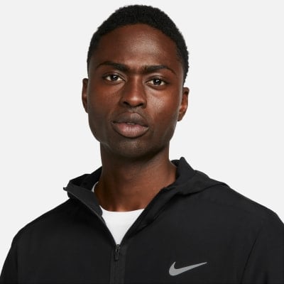 Fekete ruhát viselő férfi kapucnival és Nike logóval. Fekete ruhát viselő férfi kapucnival és Nike logóval.