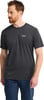 Ein Mann in einem dunklen T-Shirt und blauer Hose mit Jack Wolfskin Logo.