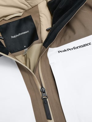 Detail einer Peak Performance Jacke mit Logo und Reißverschluss.