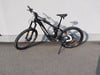 Ein schwarzes Haibike E-Mountainbike steht vor einer grauen Wand auf Asphalt.