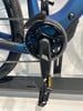 Detail des Kettenblatts und Pedals eines blauen E-Bikes mit Kette.
