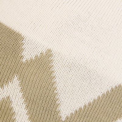 Detail eines Strickmusters mit beige Musterung und ausgefransten Kanten. Detail eines Strickmusters mit beige Musterung und ausgefransten Kanten.