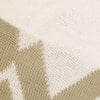 Detail eines Strickmusters mit beige Musterung und ausgefransten Kanten.