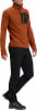 Mann in einem orangefarbenen Pullover mit kurzem Reißverschluss und schwarzer Hose.