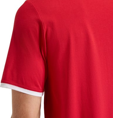 Detail eines roten T-Shirts mit weißem Bündchen am Ärmel. Detail eines roten T-Shirts mit weißem Bündchen am Ärmel.