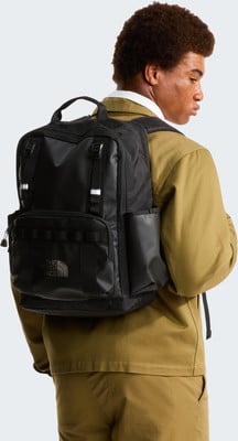 Ein Mann mit einem schwarzen Rucksack von The North Face auf dem Rücken. Ein Mann mit einem schwarzen Rucksack von The North Face auf dem Rücken.